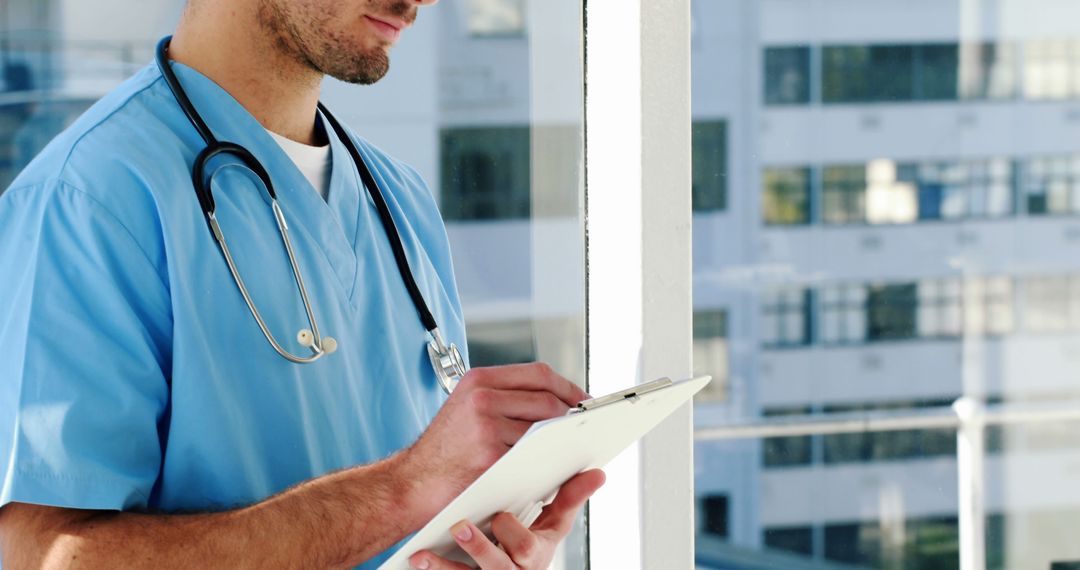 Doctor Writing Notes on Clipboard in Modern Hospital Setting - Free Images, Stock Photos and Pictures on Pikwizard.com