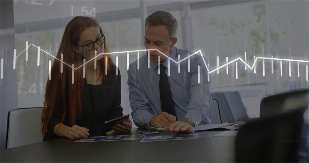 Business Professionals Reviewing Financial Charts and Tablet Data in Modern Boardroom