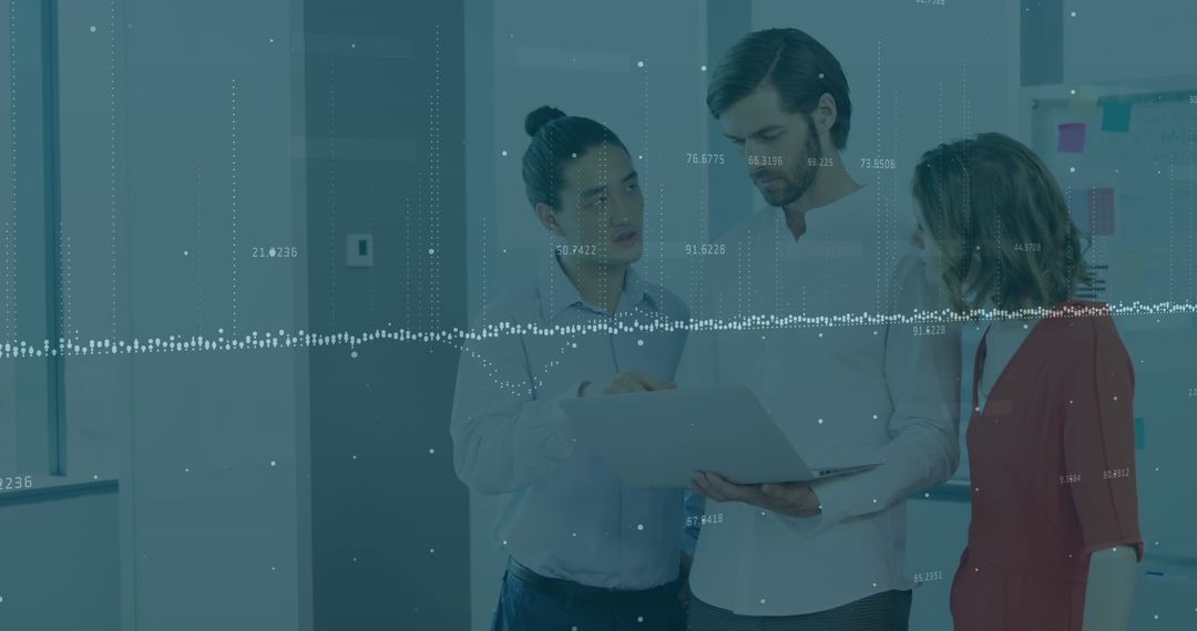 Diverse Team Analyzing Data on Laptop in Modern Office