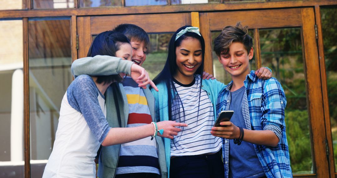 Group of Teenagers Laughing and Looking at Phone Outdoors - Free Images, Stock Photos and Pictures on Pikwizard.com