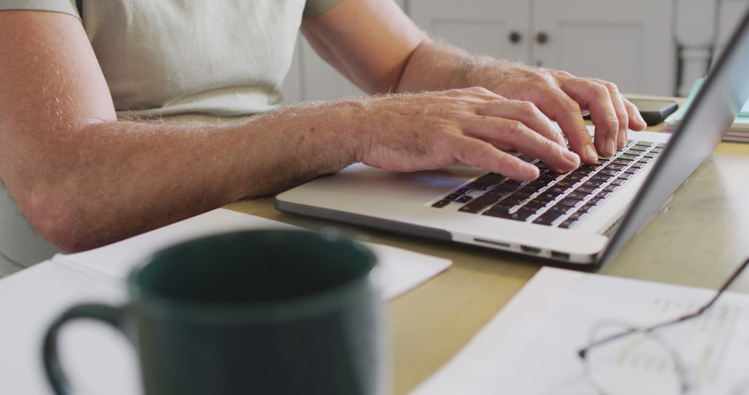 Man Typing on Laptop at Desk with Coffee Mug - Free Images, Stock Photos and Pictures on Pikwizard.com