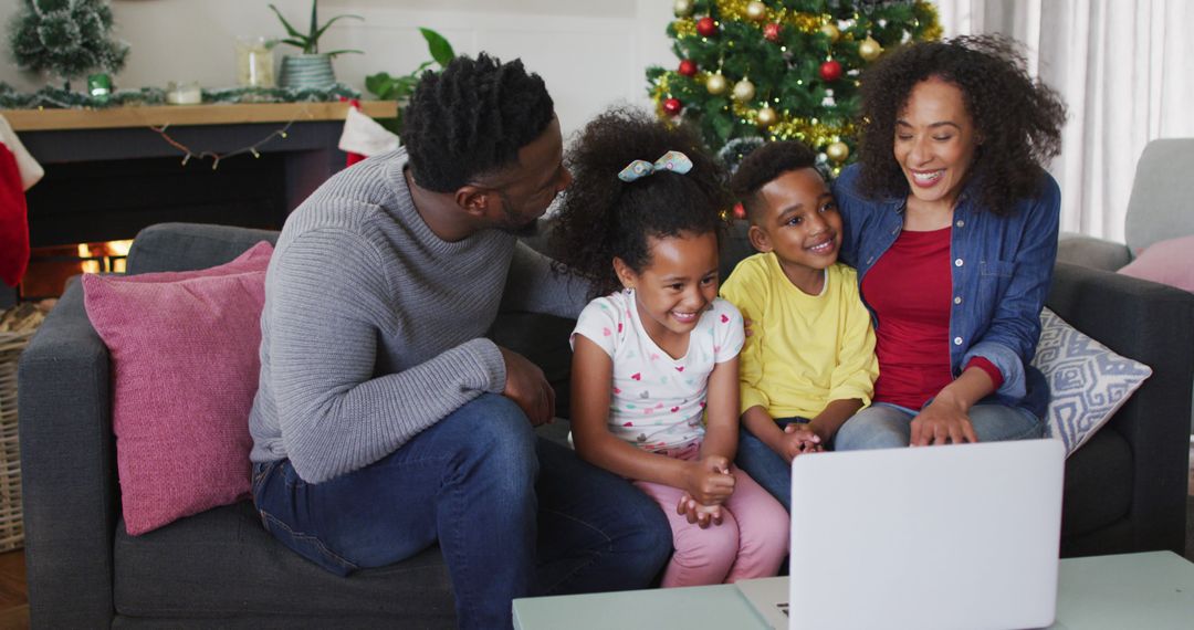 An African American family enjoys a festive video call amidst Christmas decor at home. - Free Images, Stock Photos and Pictures on Pikwizard.com