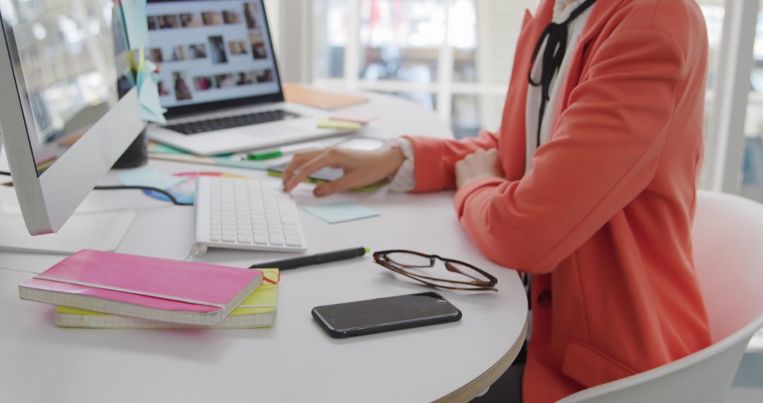 Professional Woman in Bright Blazer Using Computer at Office Desk