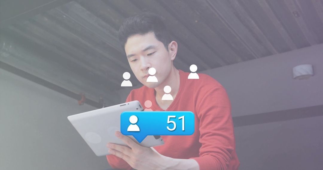 Young Man Engaged with Tablet Displaying Social Media Notifications