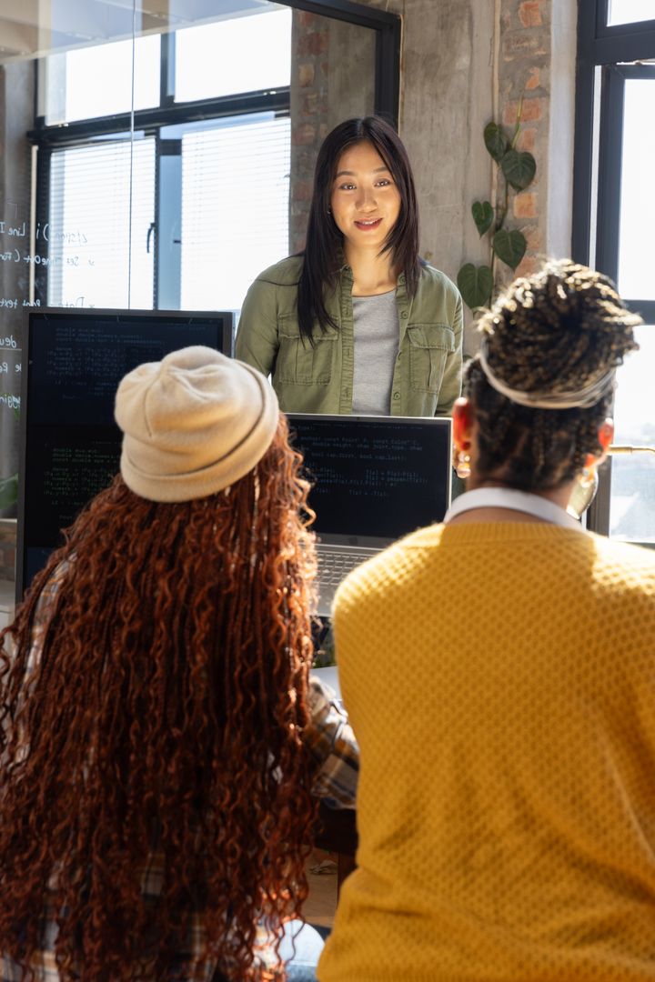 Diverse Female Professionals Collaborating in Modern Office on Coding Project