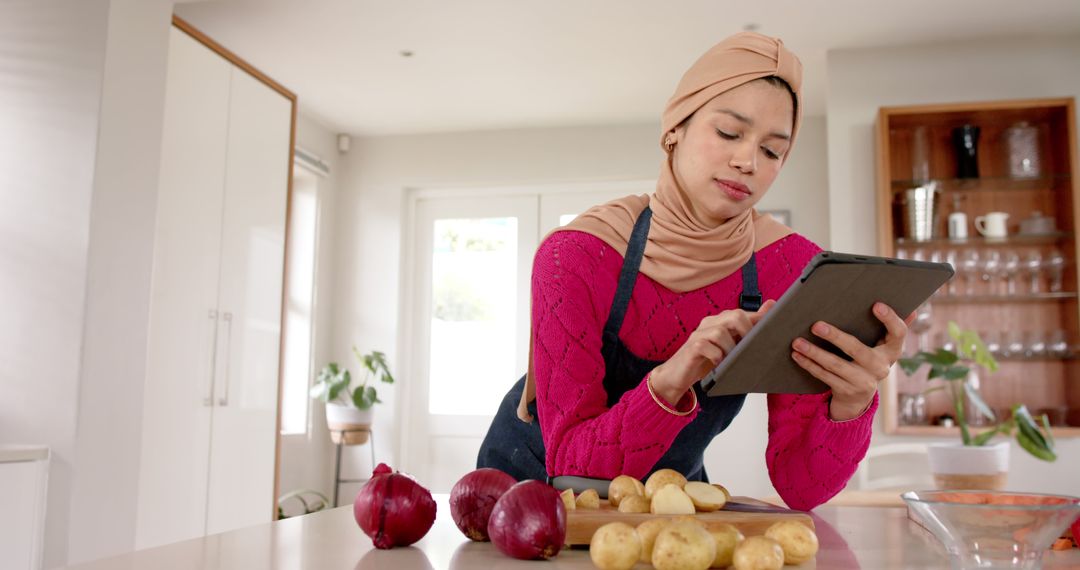 Woman in Hijab Using Tablet for Online Recipe in Modern Kitchen - Free Images, Stock Photos and Pictures on Pikwizard.com