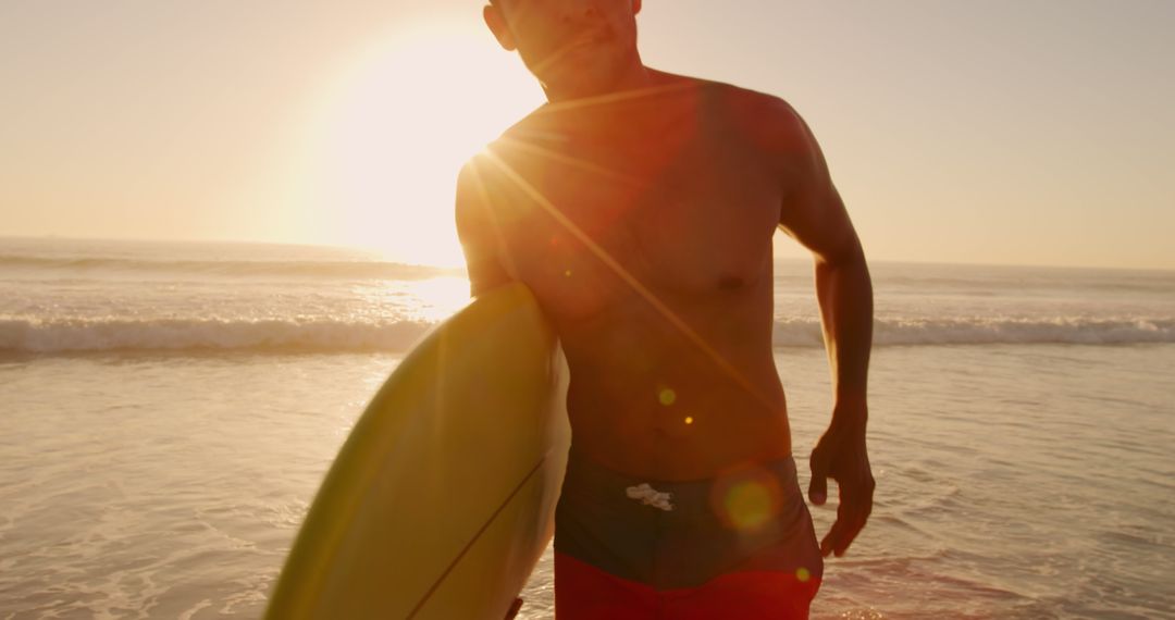 Surfer Holding Board in Sunset at the Beach - Free Images, Stock Photos and Pictures on Pikwizard.com