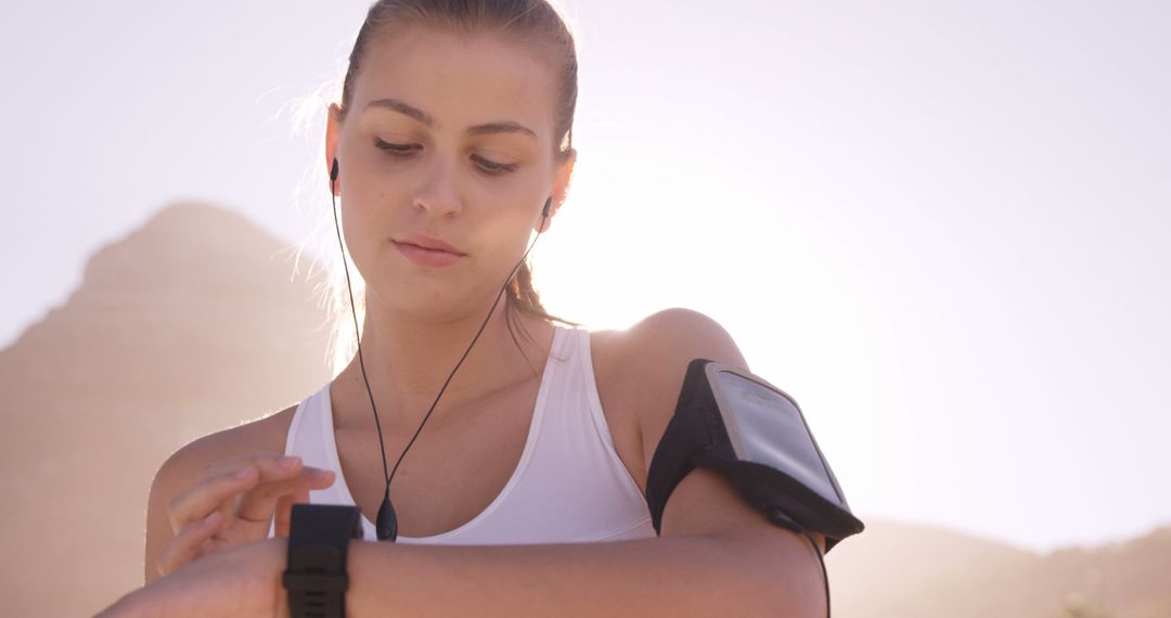 Active Woman Checking Fitness Tracker on Sunny Day - Free Images, Stock Photos and Pictures on Pikwizard.com