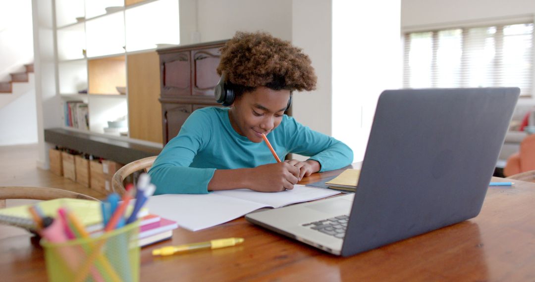 Boy Wearing Headphones Studying Online at Home