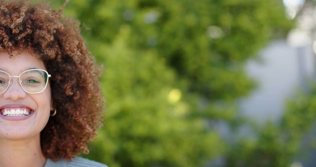 Half-Face of Smiling Woman with Afro Hair and Glasses Outdoors - Free Images, Stock Photos and Pictures on Pikwizard.com