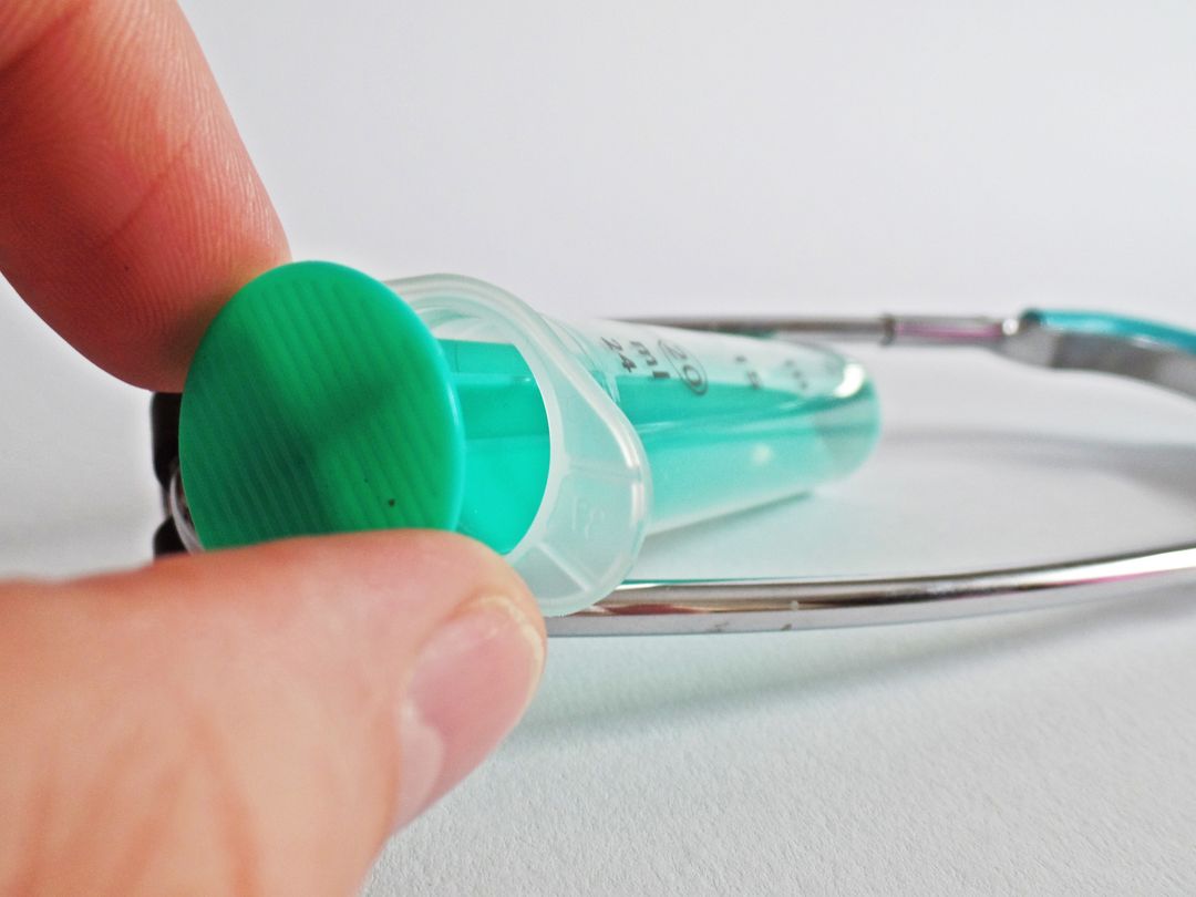 Doctor Holding Syringe with Stethoscope in Background - Free Images, Stock Photos and Pictures on Pikwizard.com