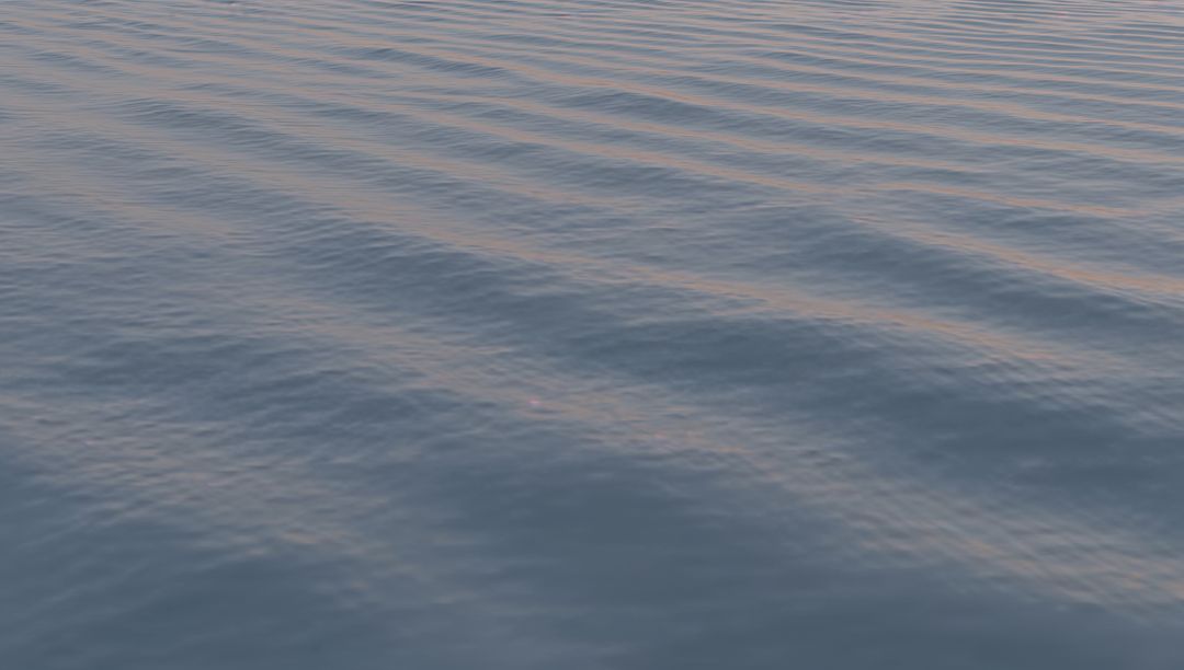 Shimmering Ocean Surface with Soft Diagonal Ripples and Warm Sunset Reflections