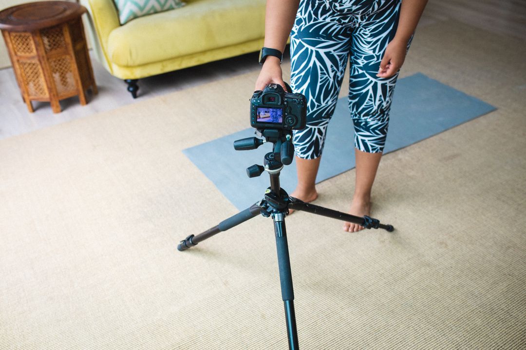 African American blogger adjusts camera for a home fitness video. - Free Images, Stock Photos and Pictures on Pikwizard.com