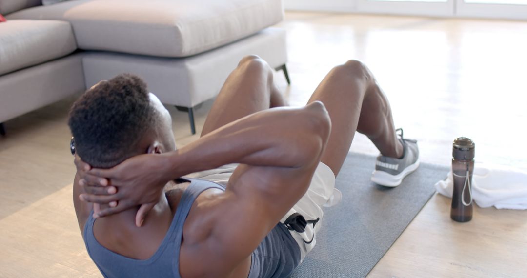 Man Exercising at Home Doing Sit-ups in Living Room - Free Images, Stock Photos and Pictures on Pikwizard.com