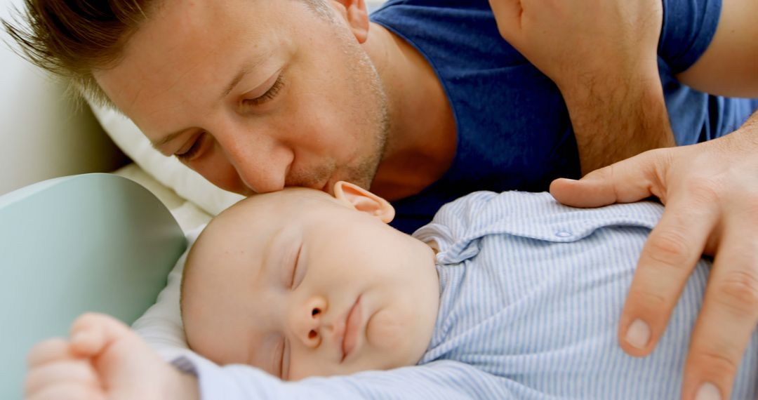 A Caucasian man gently kisses his sleeping baby, with copy space - Free Images, Stock Photos and Pictures on Pikwizard.com