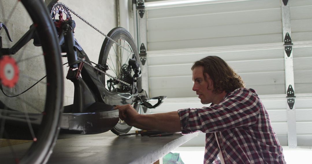 Man repairing bicycle in garage workshop - Free Images, Stock Photos and Pictures on Pikwizard.com