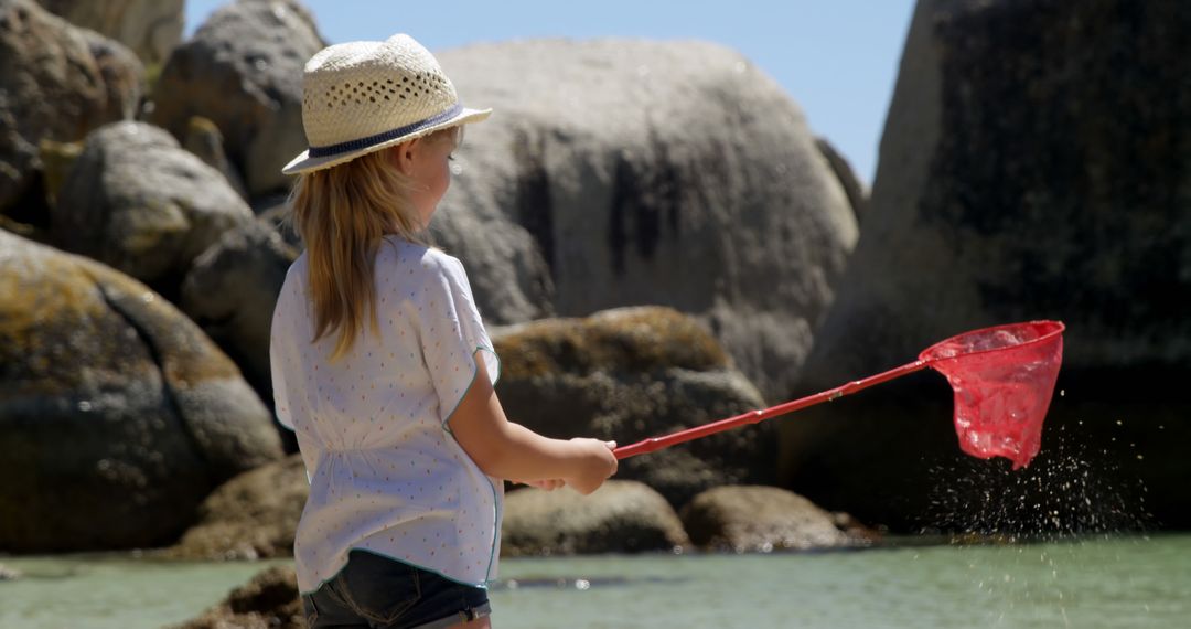 Girl Fishing with Net by Rock Formation in Summer - Free Images, Stock Photos and Pictures on Pikwizard.com