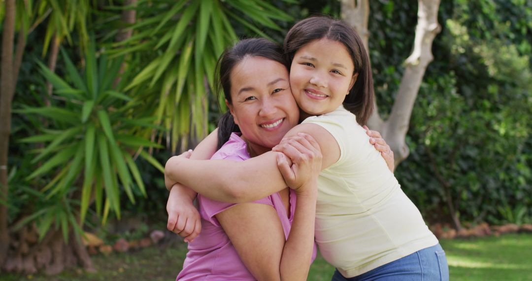 Smiling Mother and Daughter Hugging in Lush Garden - Free Images, Stock Photos and Pictures on Pikwizard.com