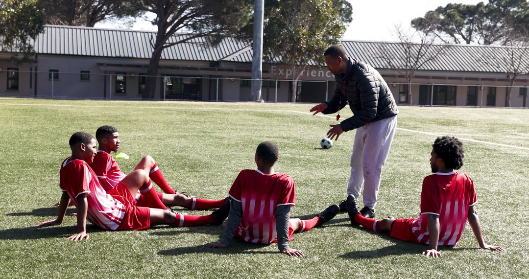 Soccer Team Receiving Feedback and Building Team Spirit on School Field