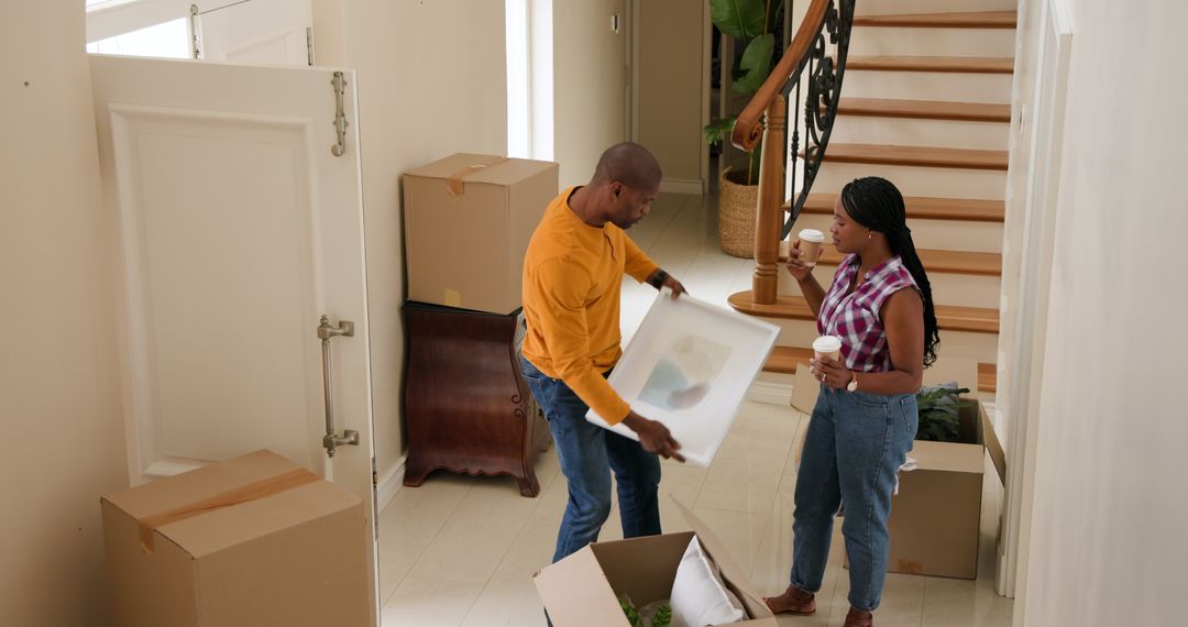 Couple Unpacking in New Home with Boxes and Artwork