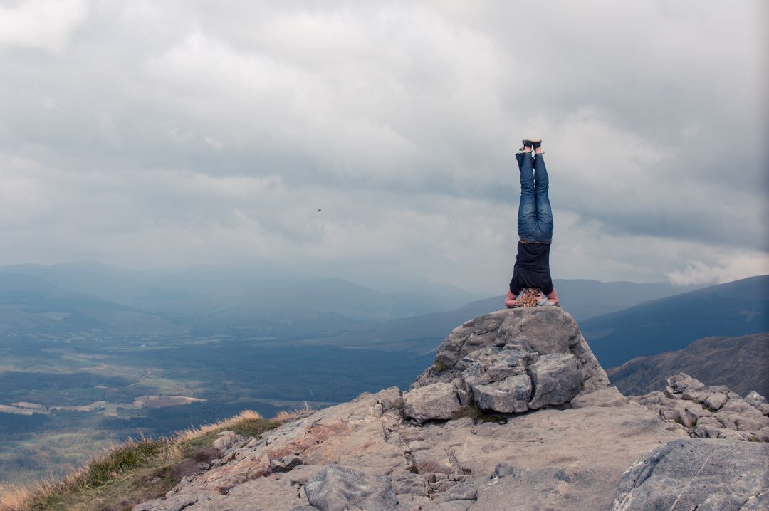 Person Doing a Headstand on Rocky Mountain Top