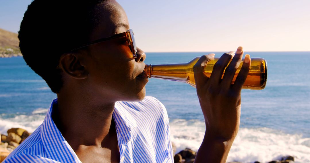 Person Enjoying Beer at Beach During Sunny Day - Free Images, Stock Photos and Pictures on Pikwizard.com