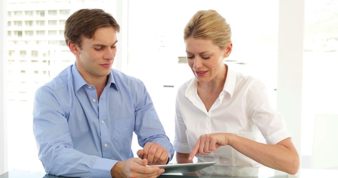 Business Partners Collaborating on Tablet in Modern Office