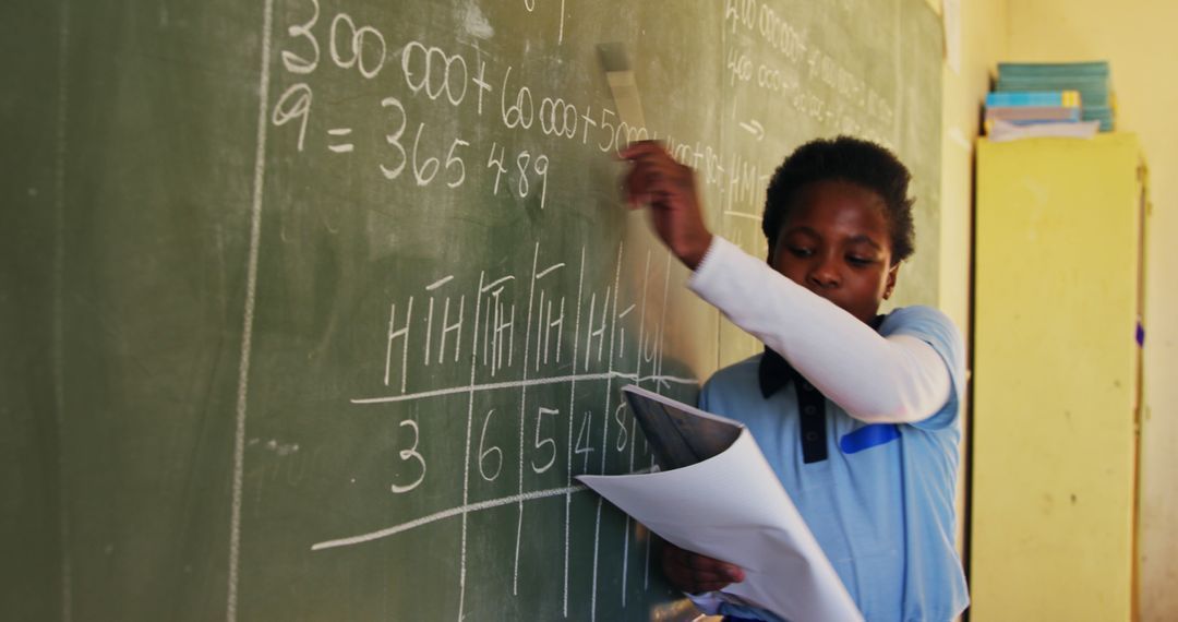 Focused African American Student Writing on Classroom Chalkboard - Free Images, Stock Photos and Pictures on Pikwizard.com