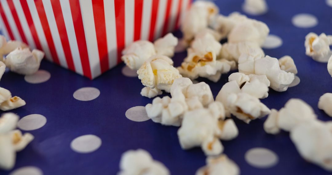 Colorful Popcorn Box with Scattered Popcorn on Polka Dot Surface - Free Images, Stock Photos and Pictures on Pikwizard.com