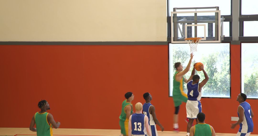Intense Basketball Match with Players Dunking and Blocking