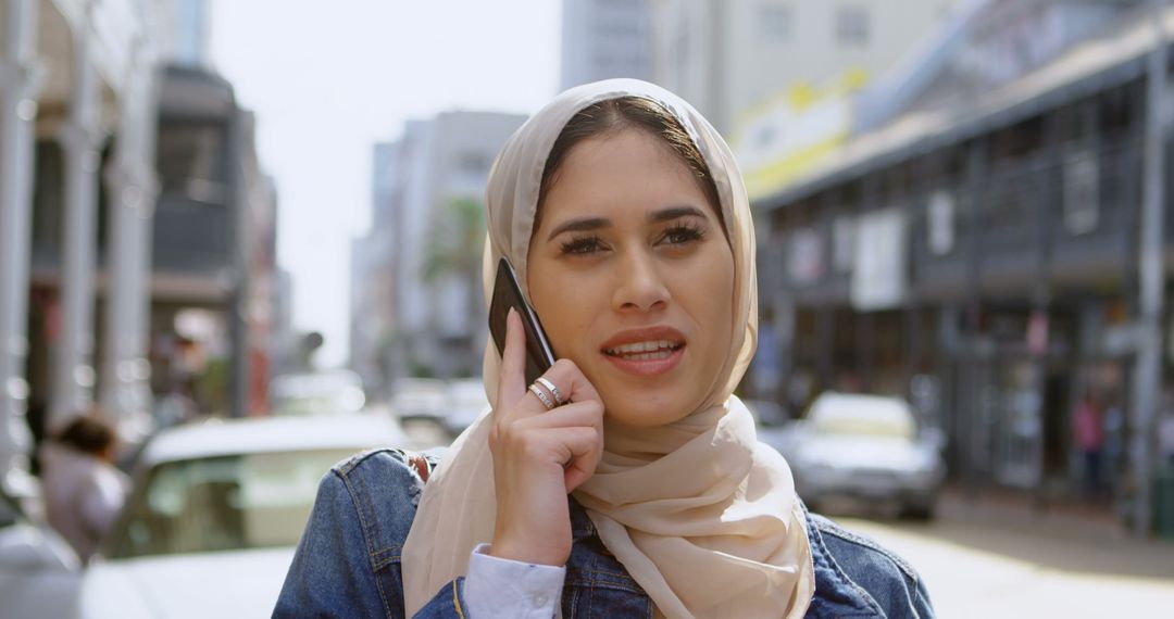 Middle Eastern Woman Talking on Smartphone Outdoors - Free Images, Stock Photos and Pictures on Pikwizard.com