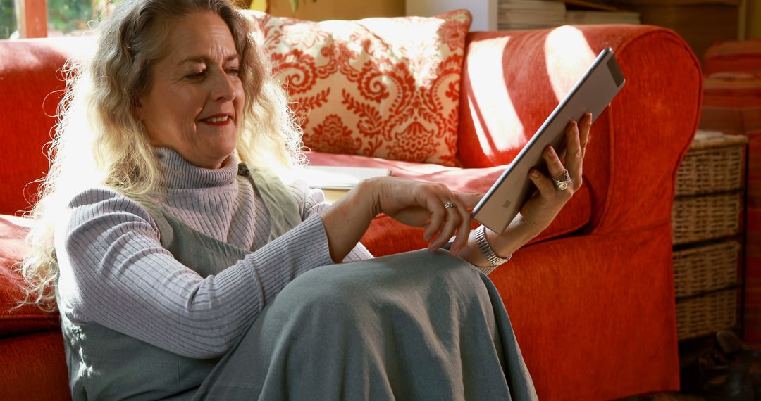 Elderly Woman Reading Tablet in Cozy Living Room - Free Images, Stock Photos and Pictures on Pikwizard.com