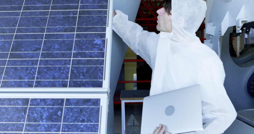 Engineer Testing Solar Panels with Laptop in Protective Suit - Free Images, Stock Photos and Pictures on Pikwizard.com