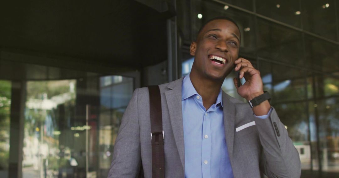 Confident Businessman Smiling While Communicating via Smartphone