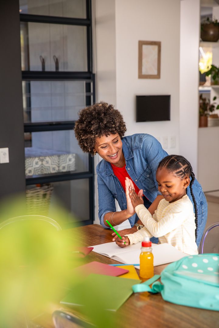 Joyful Mother Giving High Five to Daughter During Creative Drawing