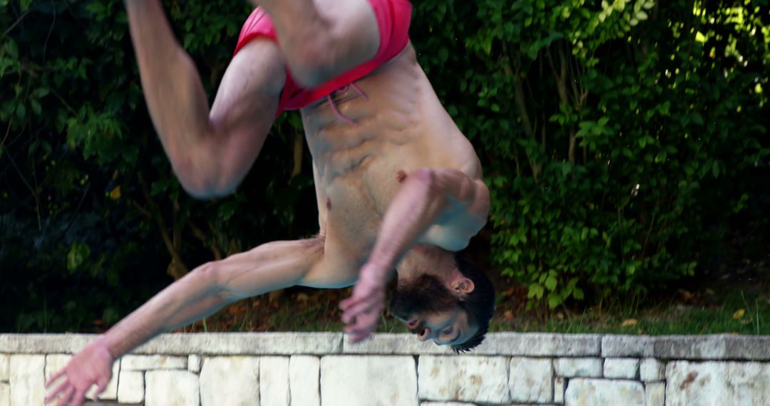 Man Mid-Somersault by Outdoor Pool - Free Images, Stock Photos and Pictures on Pikwizard.com