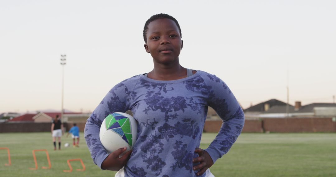 Confident Young African Woman Holding Rugby Ball on Field - Free Images, Stock Photos and Pictures on Pikwizard.com