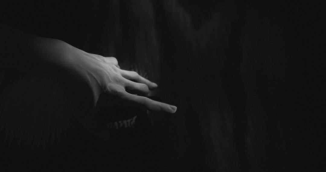 Mysterious Hand Reaching Out in Dark Void