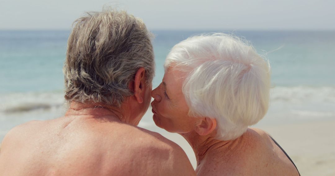 Elderly Couple Kissing on Beach Enjoying Retirement - Free Images, Stock Photos and Pictures on Pikwizard.com