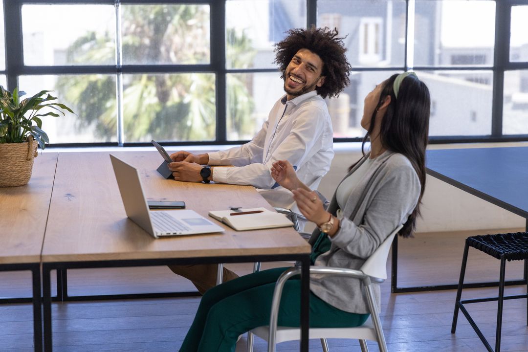 Diverse Coworkers Engaging in Discussion at Modern Office Desk