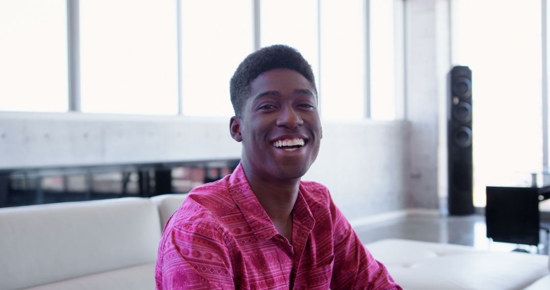 Happy Man in Bright Outfit Relaxing in Modern Living Space