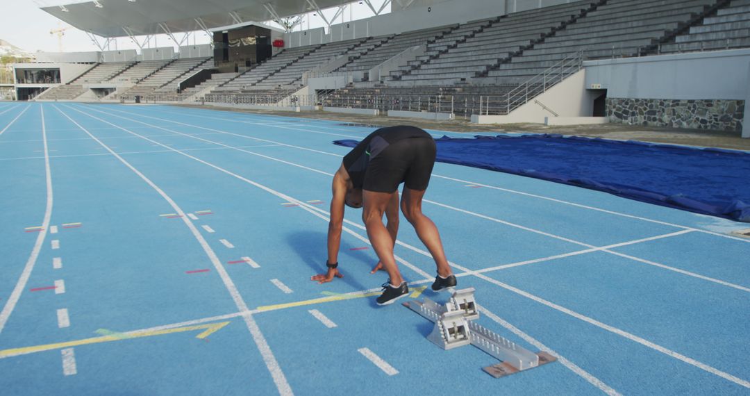 Runner Preparing for Sprint on Blue Olympic Track Stadium