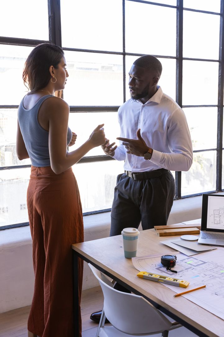 Diverse Colleagues Collaborating at Architectural Workspace
