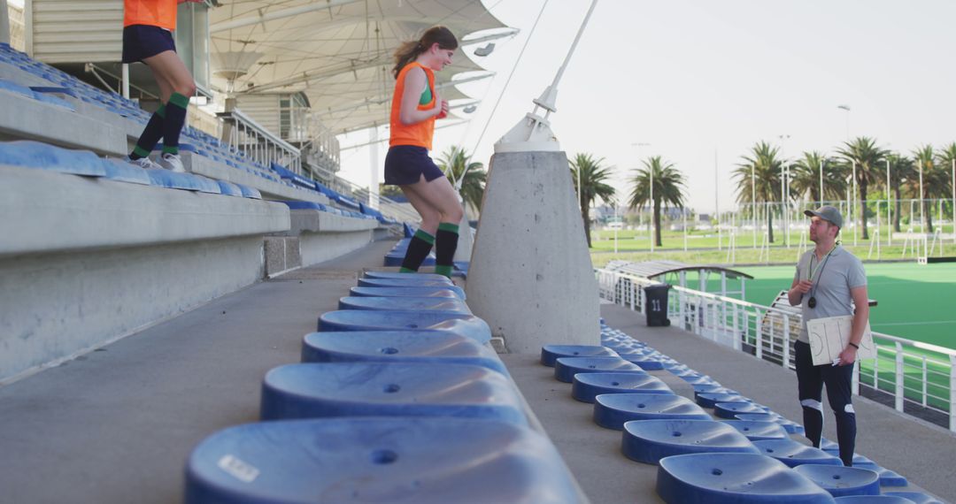 Female Athletes Training in Stadium with Coach on Sunny Day - Free Images, Stock Photos and Pictures on Pikwizard.com