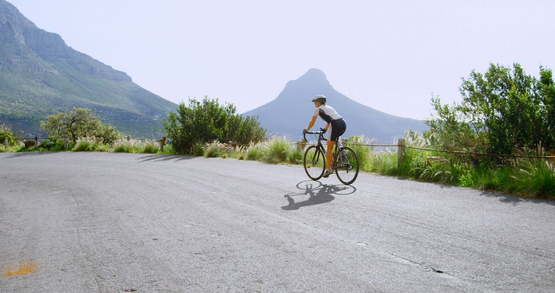 Cyclist Riding on Mountain Road on Sunny Day - Free Images, Stock Photos and Pictures on Pikwizard.com