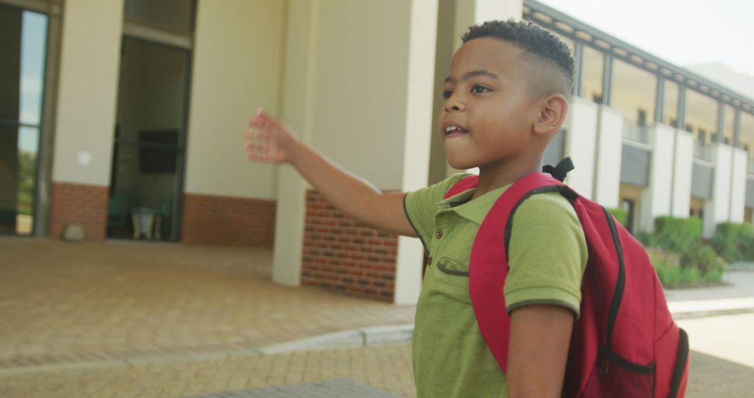 Joyful School Boy Waving Goodbye with Red Backpack