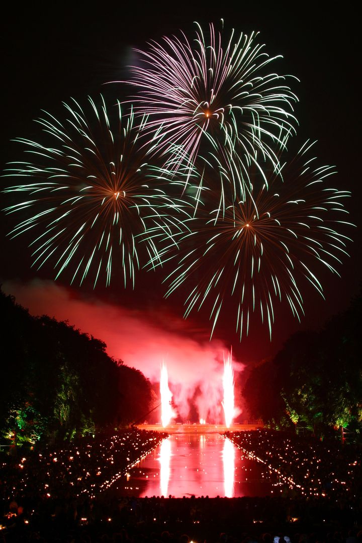 Vibrant Fireworks Exploding Over Water at Nighttime Event - Free Images, Stock Photos and Pictures on Pikwizard.com
