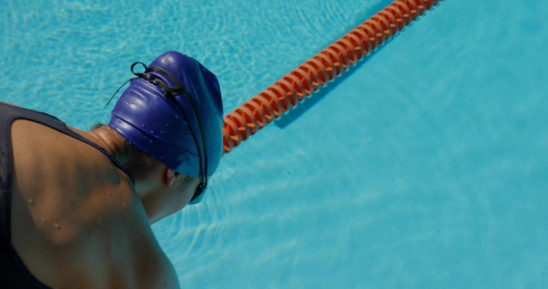 Competitive Swimmer Preparing by Outdoor Pool with Blue Cap