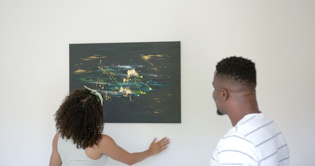 Couple Discussing Abstract Art Piece on Wall