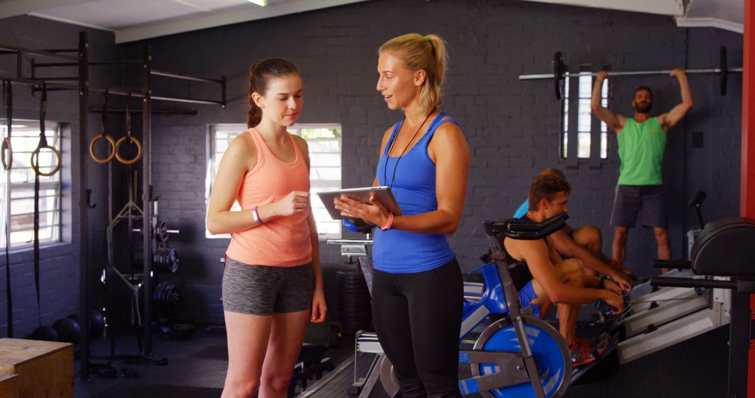 Female Trainer Instructing Woman during Workout in Gym - Free Images, Stock Photos and Pictures on Pikwizard.com